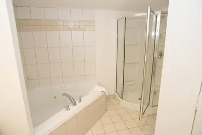a white bathroom with a tub and a shower at Super 8 by Wyndham Mississauga in Mississauga