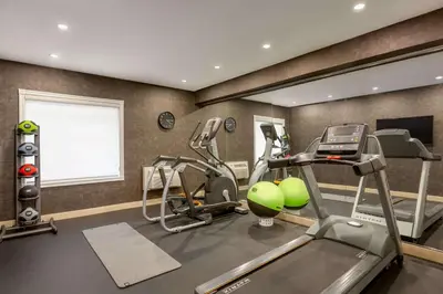 a gym with two tread machines and a mirror at Days Inn by Wyndham Toronto West Mississauga in Mississauga