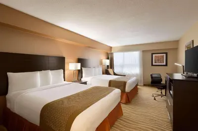 a hotel room with two beds and a television at Park Inn by Radisson Toronto-Markham in Markham