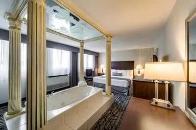 a hotel room with a tub and a bed at Monte Carlo Inn Oakville Suites in Oakville