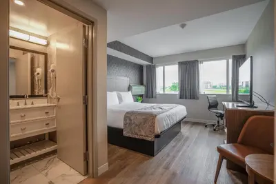 a hotel room with a bed and a desk at Monte Carlo Inn Oakville Suites in Oakville