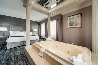 a hotel room with a tub and a bed at Monte Carlo Inn Brampton in Brampton