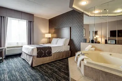 a hotel room with a bed and a bath tub at Monte Carlo Inn Brampton in Brampton