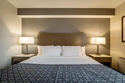 a hotel room with a large bed with two lamps at Monte Carlo Inn Airport Suites in Mississauga