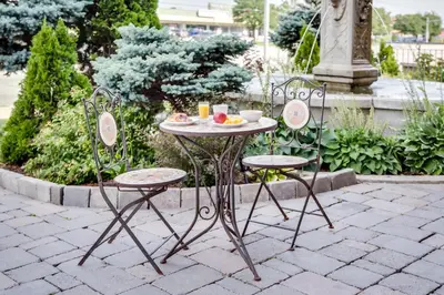a table and two chairs with a plate of food on it at Monte Carlo Inn Toronto West Suites in Mississauga