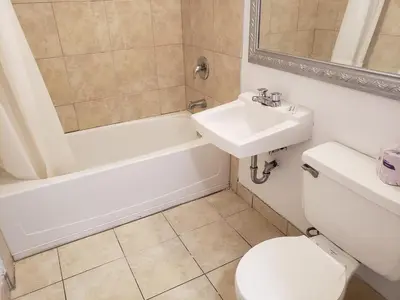 a bathroom with a sink and a toilet and a shower at Niagara Falls Courtside Inn in Niagara Falls