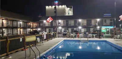 a pool in front of a hotel at night at Niagara Falls Courtside Inn in Niagara Falls