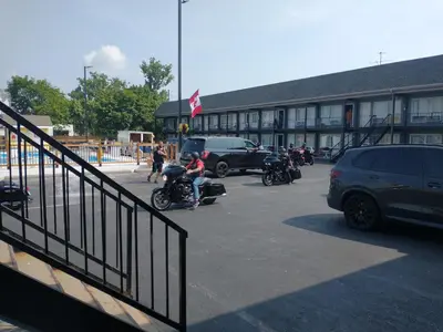 a group of people riding motorcycles in a parking lot at Niagara Falls Courtside Inn in Niagara Falls
