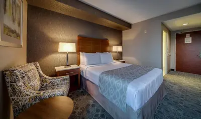 a hotel room with a bed and a chair at Monte Carlo Inn Markham in Markham