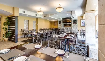 a dining room with tables and chairs in a restaurant at Monte Carlo Inn Markham in Markham