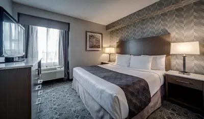 a hotel room with a large bed and a television at Monte Carlo Inn Markham in Markham
