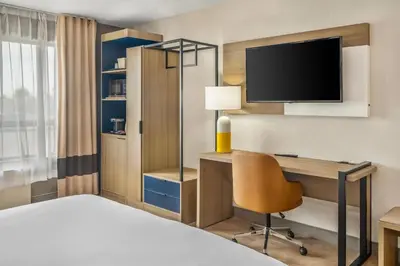 a hotel room with a bed and a desk and a tv at Comfort Inn in London