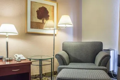a room with a chair and a table and a phone at Comfort Inn in London