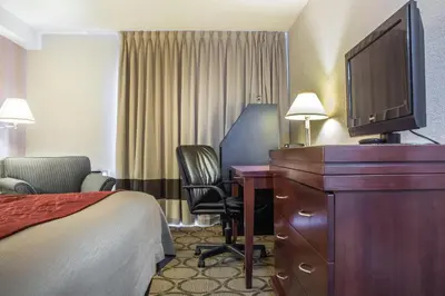 a hotel room with a bed a desk and a tv at Comfort Inn in London