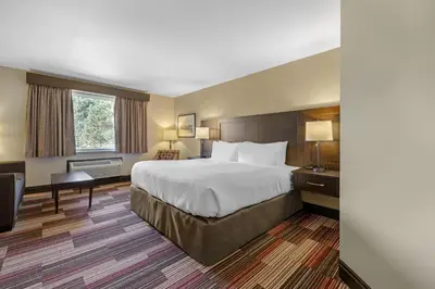 a hotel room with a large bed and a desk at Best Western Plus Stoneridge Inn & Conference Centre London Ontario in London