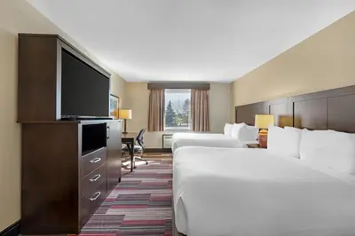 a hotel room with two beds and a flat screen tv at Best Western Plus Stoneridge Inn & Conference Centre London Ontario in London