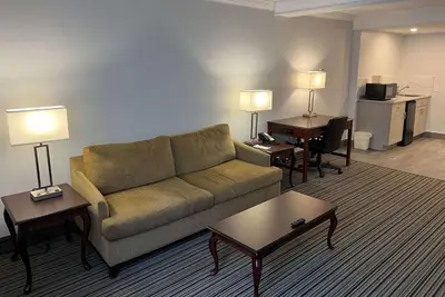 a living room with a couch and a desk at Ramada by Wyndham London in London