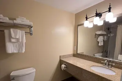 a bathroom with a toilet and a sink and a mirror at Ramada by Wyndham London in London