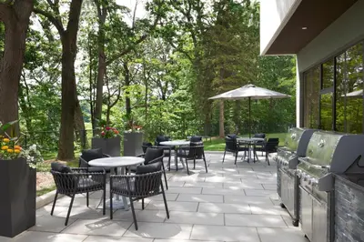 a patio with tables and chairs and trees at TownePlace Suites by Marriott Toronto Oakville in Oakville