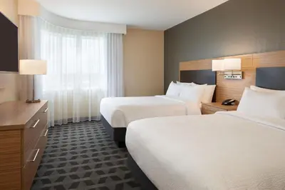 a hotel room with two beds and a window at TownePlace Suites by Marriott Toronto Oakville in Oakville
