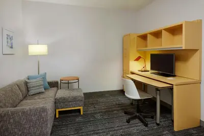 a hotel room with a desk and a couch and a computer at TownePlace Suites by Marriott London in London