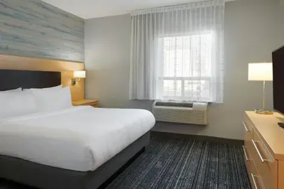 a hotel room with a bed and a window at TownePlace Suites by Marriott London in London