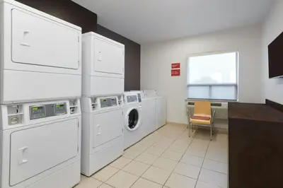 a white laundry room with a washer and dryer at TownePlace Suites by Marriott London in London