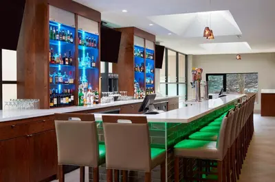 a bar with green seats in a restaurant at Four Points by Sheraton Toronto Airport in Mississauga