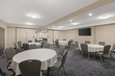 a conference room with tables and chairs and a tv at Quality Inn & Suites Oakville-Mississauga in Oakville