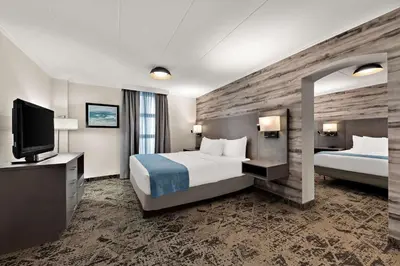 a hotel room with two beds and a flat screen tv at Best Western Parkway Hotel Toronto North in Richmond Hill