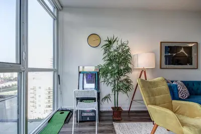 a living room with a couch a chair and a table at The Benetton Suite - Square One 1 BR + Den + 1 Parking in Mississauga