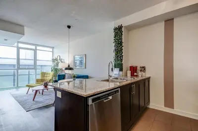 a kitchen with a sink and a counter top at The Benetton Suite - Square One 1 BR + Den + 1 Parking in Mississauga