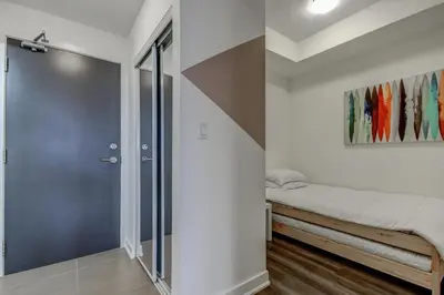 a bedroom with a sliding glass door and a bed at The Benetton Suite - Square One 1 BR + Den + 1 Parking in Mississauga
