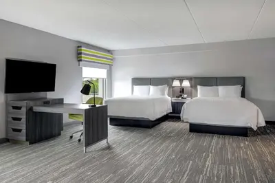 a hotel room with two beds and a flat screen tv at Hampton Inn & Suites Burlington, Ontario, Canada in Burlington