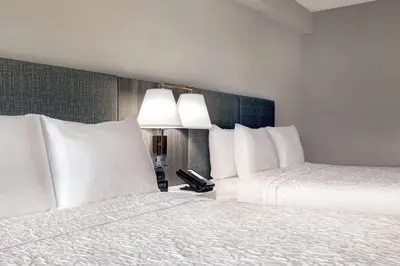 two beds with white pillows in a hotel room at Hampton Inn & Suites Burlington, Ontario, Canada in Burlington