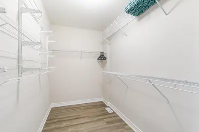 a walk in closet with white walls and glass shelves at GlobalStay Waterfront 5 Bedroom Townhouse Hot tub Sauna Stoney Creek in Hamilton