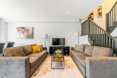 a living room with two couches and a tv at GlobalStay Waterfront 5 Bedroom Townhouse Hot tub Sauna Stoney Creek in Hamilton