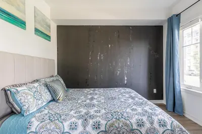 a bedroom with a bed with a blue and white bedspread at GlobalStay Waterfront 5 Bedroom Townhouse Hot tub Sauna Stoney Creek in Hamilton