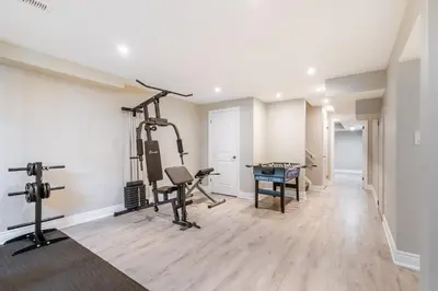 a room with a gym with tread machines and a desk at GlobalStay Waterfront 5 Bedroom Townhouse Hot tub Sauna Stoney Creek in Hamilton