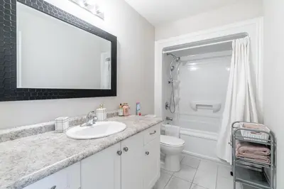 a bathroom with a sink and a toilet and a mirror at GlobalStay Waterfront 5 Bedroom Townhouse Hot tub Sauna Stoney Creek in Hamilton
