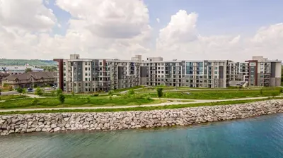 an apartment building next to a body of water at GlobalStay Waterfront 5 Bedroom Townhouse Hot tub Sauna Stoney Creek in Hamilton