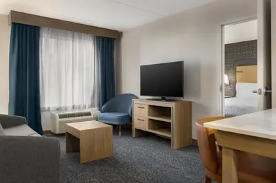 a hotel room with a television and a bed at Homewood Suites by Hilton Toronto-Ajax in Ajax