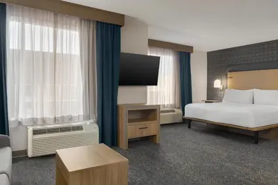 a hotel room with a bed and a flat screen tv at Homewood Suites by Hilton Toronto-Ajax in Ajax