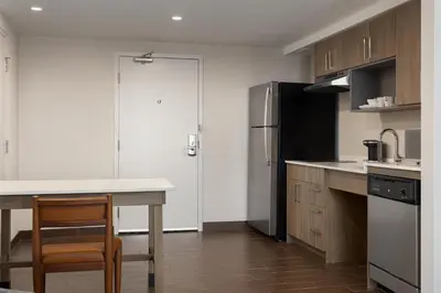 a kitchen with a table and a refrigerator at Homewood Suites by Hilton Toronto-Ajax in Ajax