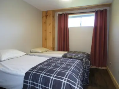 two beds in a small room with a window at 6BR Blue Mountain Chalet Hot Tub Updated Walk to Village Fun in Blue Mountains