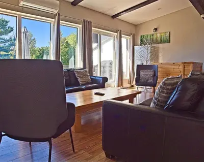 a living room with a couch and a table at 6BR Blue Mountain Chalet Hot Tub Updated Walk to Village Fun in Blue Mountains