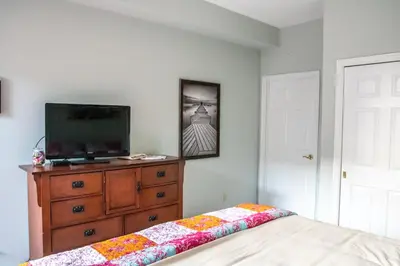 a bedroom with a television and a dresser with a bed at The Jypsy Inn / Muskoka in Bracebridge