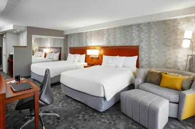 a hotel room with two beds and a couch at Courtyard by Marriott Toronto Brampton in Brampton