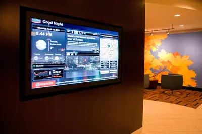 a large television on a wall in a room at Courtyard by Marriott Toronto Brampton in Brampton