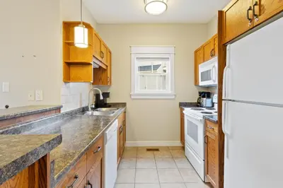 a kitchen with wooden cabinets and a white refrigerator at Blue Mountain Getaway Located on Golf Course in Blue Mountains